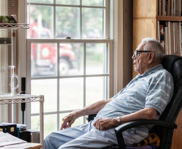 istock Elderly Man Watching Road Construction Truck Through Grungy Window 873795262