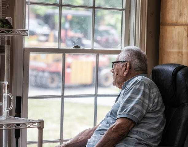 istock Elderly Man Watching Road Construction Through Grungy Window 873795298