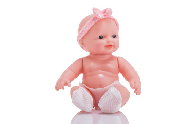 istock Cute little plastic baby doll with blue eyes sitting on empty background 873798400