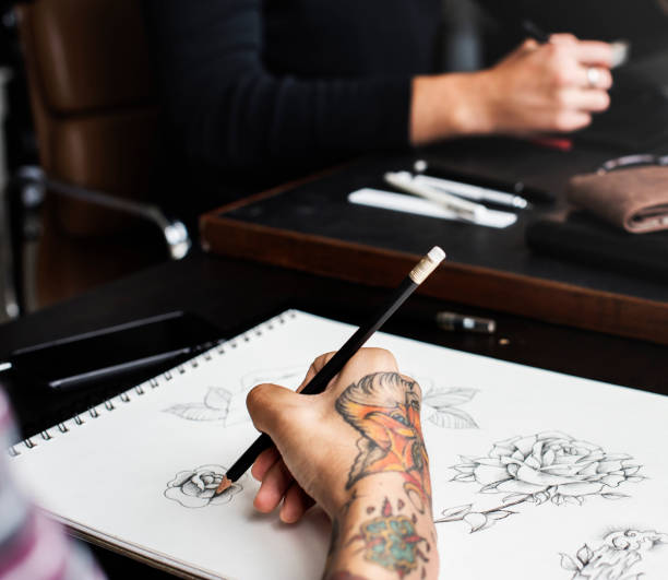 istock Closeup of tattooed hand with drawing artwork 873798628
