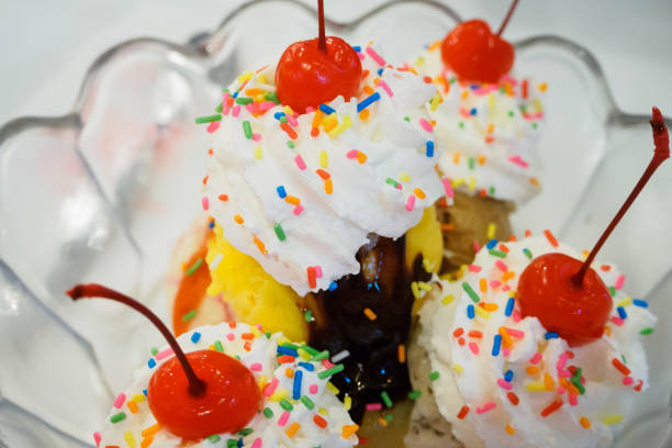 istock Ice cream sundae scoops with cherry and whipped cream in glass bowl 873806344