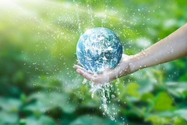 вода, льющаяся на планету земля, помещается на руку человеку для экономии ресурсов и исцеления мировой кампании, проблемы окружающей среды, - earth water green drop стоковые фото и изображения