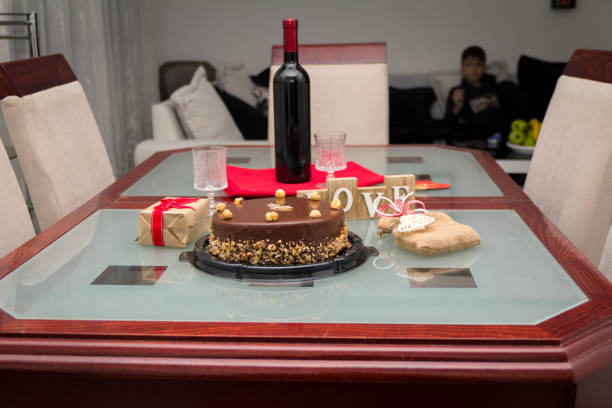 Birthday cake with gifts and wine on the table
