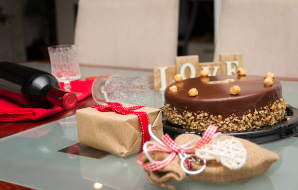 Birthday cake with gifts and wine on the table