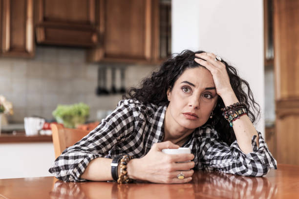 istock Worried woman sitting at home 873810174