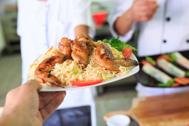 istock Chefs preparing chicken with noodles 873810696