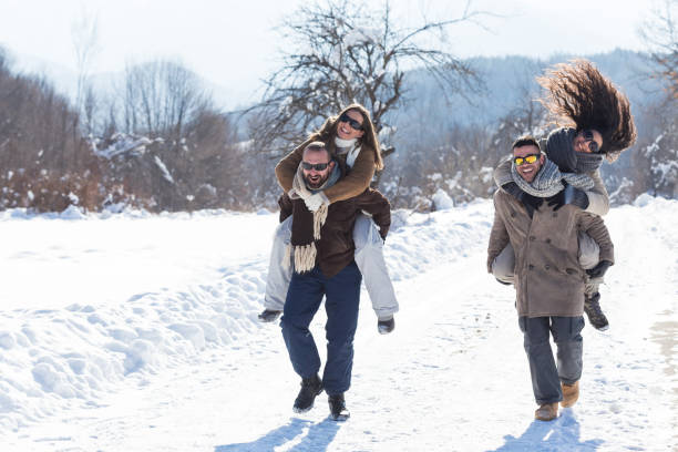 istock Young couples having fun in the snow 873810772