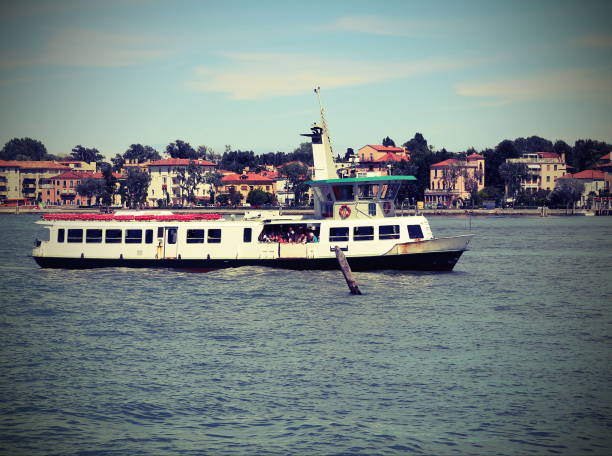 water bus navigates fast on the Venetian lagoon during the transport of tourists on the island of Venice in Italy with vintage effect