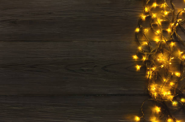 istock Christmas lights border on grey wooden background 873815138