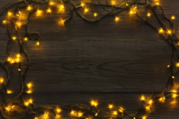 istock Christmas lights frame on wood grey background 873815180