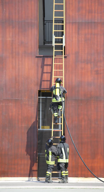istock three firefighters in the fire brigade with a long staircase 873817830