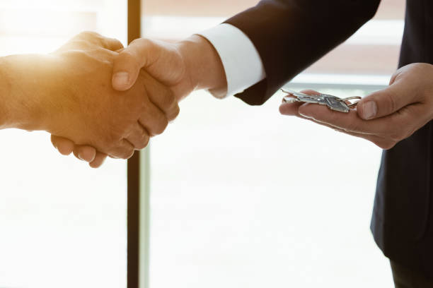Image of side view, Real estate broker agent and customer shaking hands and give keys after signing contract documents for realty purchase, Bank employees congratulate, Concept mortgage loan approval. imagen de vista lateral, real estate broker agente y cliente estrechándole la mano y dar las llaves después de firmar los documentos del contrato para la compra de bienes raíces, felicitar a los empleados del banco, aprobación del préstamo en concepto de hipoteca.