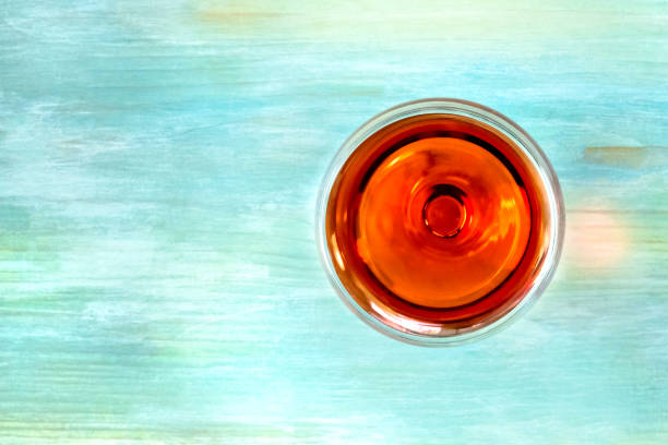 istock Vibrant wine glass on teal background with copy space 873824204