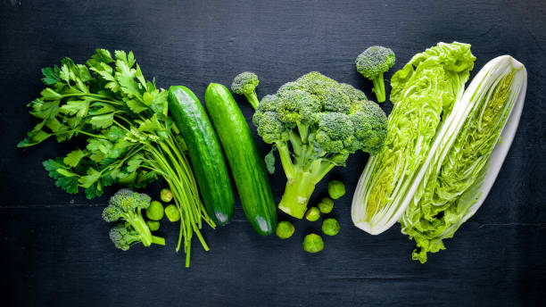 istock Collection of fresh green vegetables placed on black stone 873824930