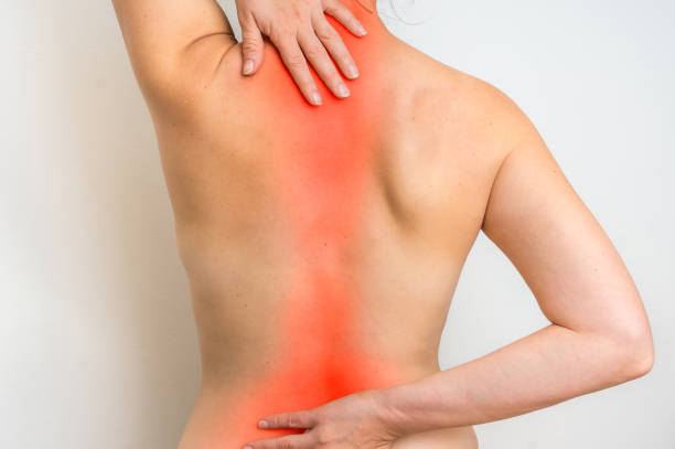 istock Woman with spine pain is holding her aching back 873826332