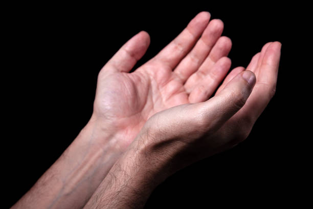 istock Male hands praying with palms up arms outstretched. 873826466