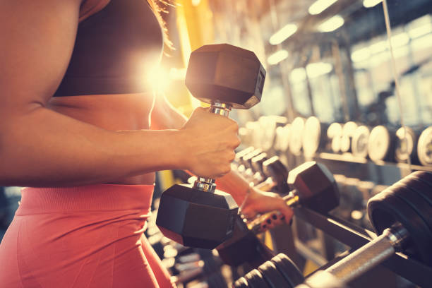 istock Fitness trainer with weights in gym, concept 873829230
