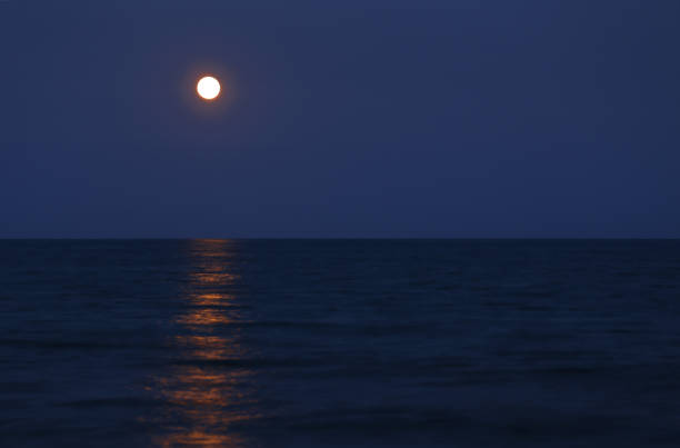 istock red full moon on the horizon over the sea 873834592