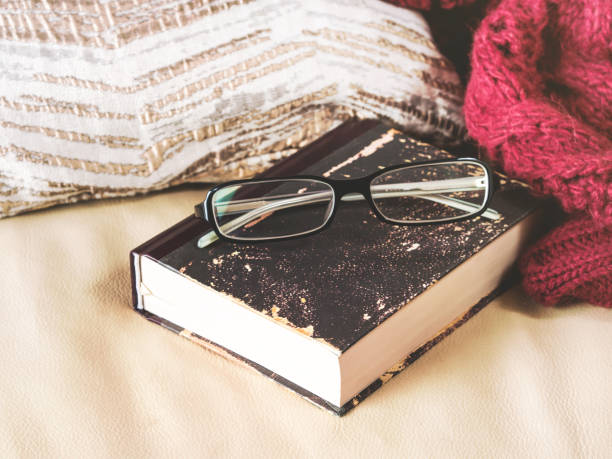 istock Glasses and book on leather sofa 873834786