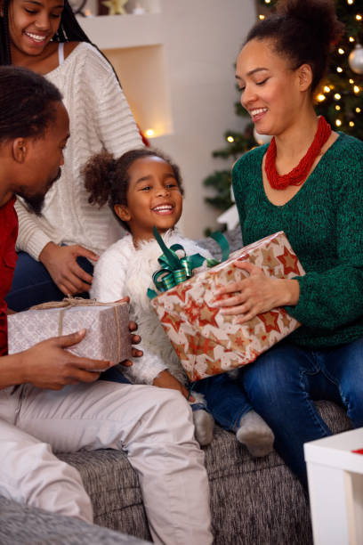 istock afro American family opening present on Christmas 873841154