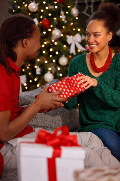 istock afro American couple exchanging present on Christmas 873842192
