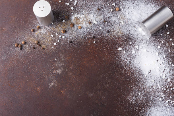 istock Scattered salt and pepper on dark background 873842804