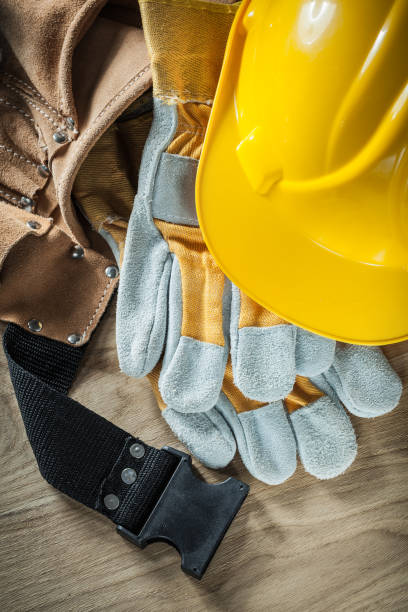 istock Leather construction belt protective gloves hard hat on wooden b 873844858