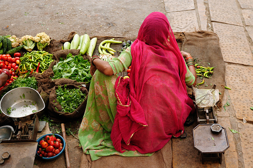 Indian Colorful woman selling the vegetables on the street.
