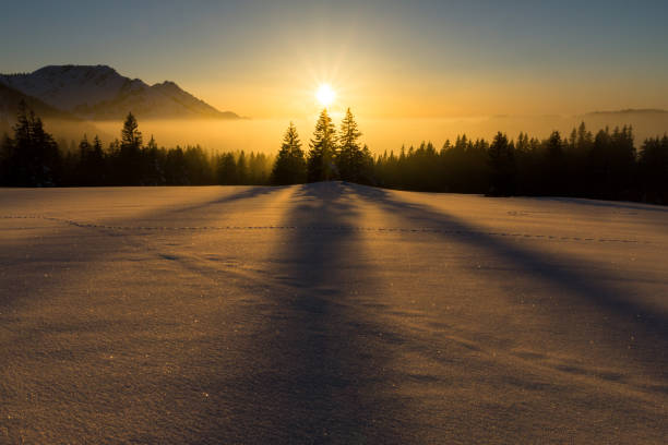 Magical sunset in a snowy mountain landscape. Sunbeams and backlighting. stock photo