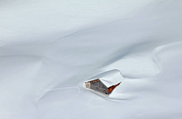 Snowed-in mountain hut in the Alps stock photo