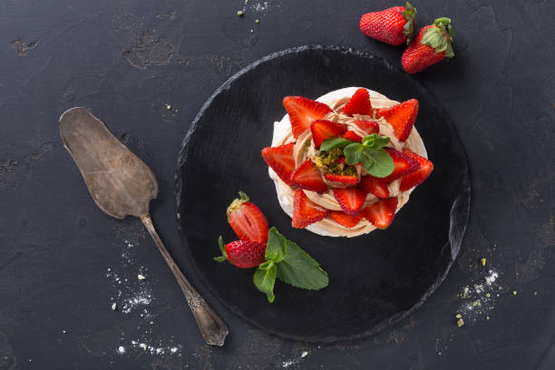 istock Anna Pavlova cake with strawberry on black background 873849878