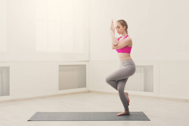 istock Woman training yoga in eagle pose. 873850272