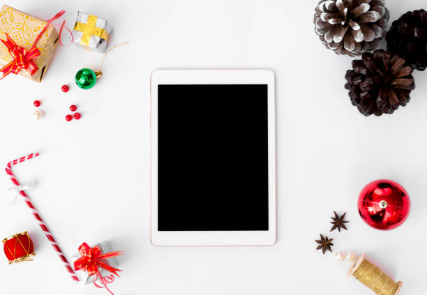 istock stylish tablet mockup for christmas time, christmas decorations on isolated white screen, flat lay top view. 873852856