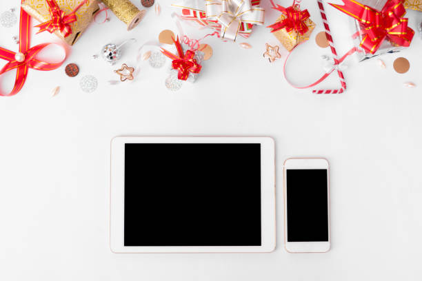istock tablet smart phone branding mock up for christmas time. christmas decorations on white back ground, flat lay top view. 873853982