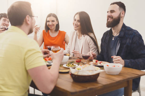 istock Group of happy young people at dinner table, friends party 873858056