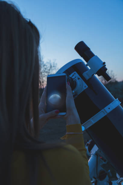 istock Photographing the Moon through a telescope with cellphone. 873858210