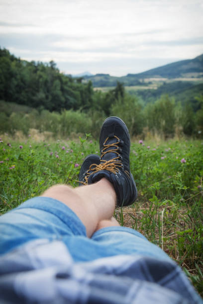 Man taking a break in nature / green field. Man taking a break in nature / green field. legs crossed at ankle stock pictures, royalty-free photos & images