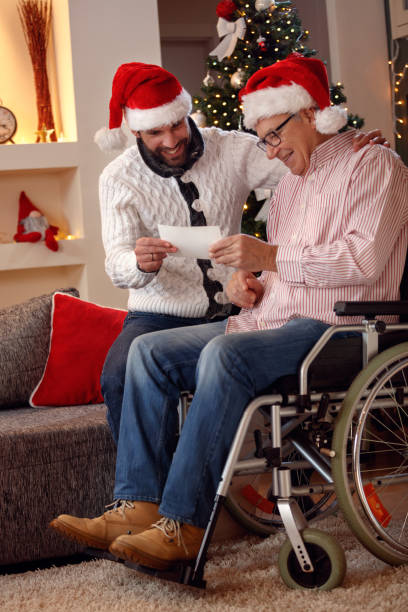 istock Happy son and his father watching photo and share memory on Christmas 873865054