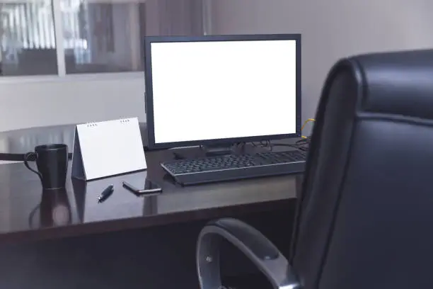 Photo of Working table with computer display and calendar with coffee cup in modern office