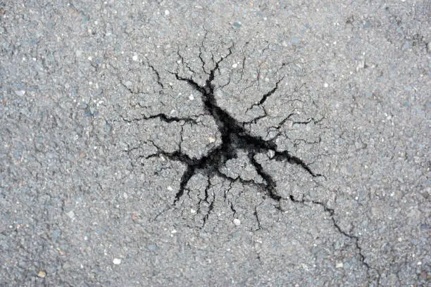 Germany: Broken concrete after winter frost with a star format crack.