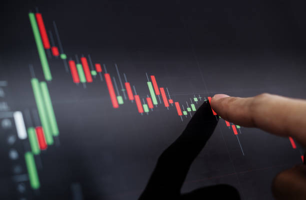istock Close-up finger pointing on stock exchange chart 873873202
