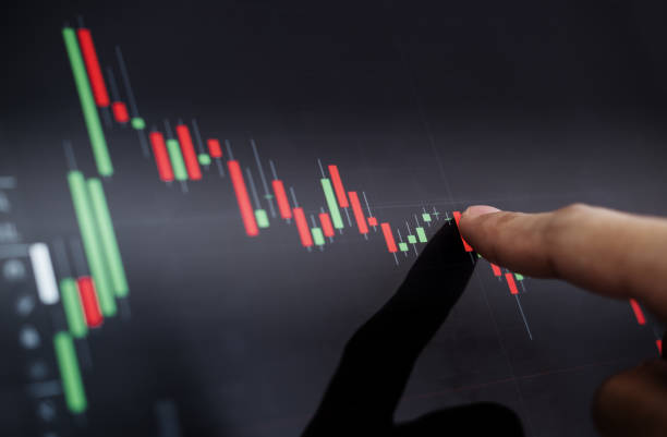 Close-up finger pointing on stock exchange chart stock photo