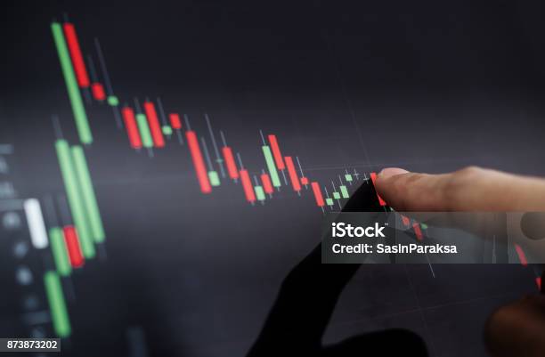 Closeup Finger Pointing On Stock Exchange Chart Stock Photo - Download Image Now - Stock Market and Exchange, Currency, Moving Down