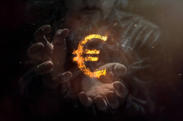 Burning symbol of euro with man in the background. Conception of risk management in money trading at currency market Burning symbol of euro with man in the background. Conception of risk management in money trading at currency market magician money stock pictures, royalty-free photos & images