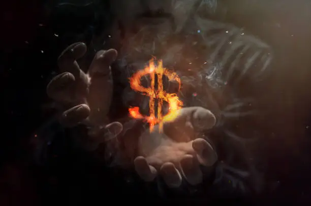 Photo of Burning symbol of dollar with man in background. Conception of risk management in money trading at currency market