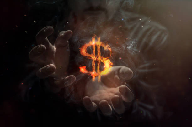 płonący symbol dolara z człowiekiem w tle. koncepcja zarządzania ryzykiem w handlu pieniądzami na rynku walutowym - greed zdjęcia i obrazy z banku zdjęć