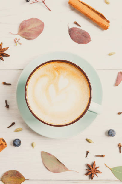 istock Autumn cappuccino coffee cup on white wood background 873879010