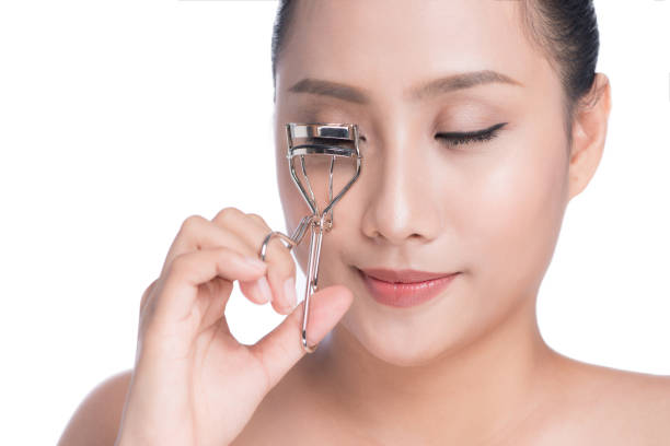 istock Stylist makes professional eye makeup. Beautiful asian model. 873879322