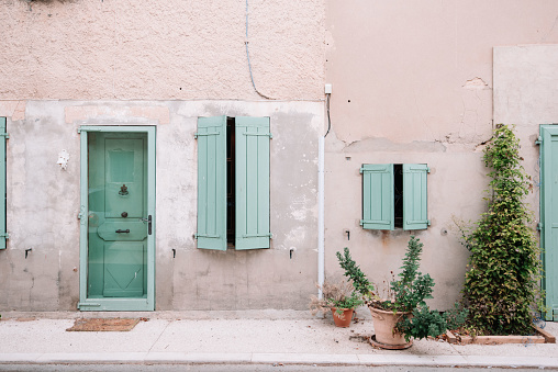 Facade with freshly painted turquoise blue mediterranean shutters