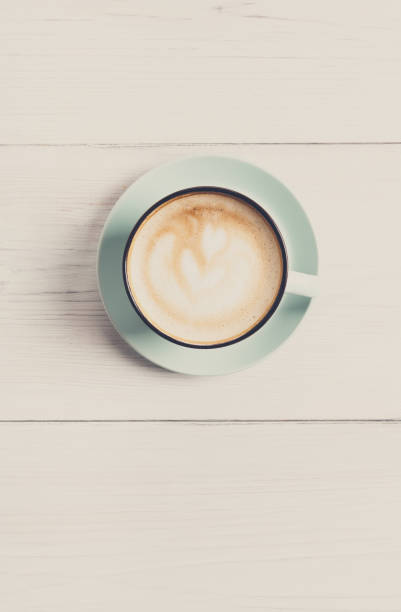 istock Cappuccino foam, coffee cup top view on white wood background 873881702